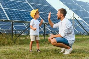 contento padre e il suo poco figlio siamo a piedi vicino il solare pannelli. il concetto di verde energia. foto