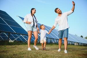 contento famiglia vicino solare pannelli. alternativa energia fonte foto