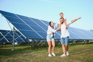 contento famiglia vicino solare pannelli. alternativa energia fonte foto