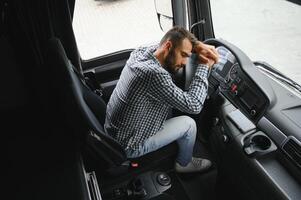 uomo camionista stanco guida nel un' cabina di il suo camion foto