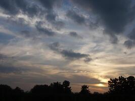 spettacolare tramonto Sopra, arancia sole crescente su al di sopra di il orizzonte foto