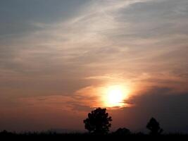 spettacolare tramonto Sopra, arancia sole crescente su al di sopra di il orizzonte foto