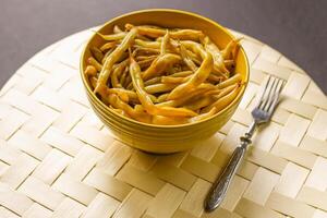 fritte lungo francese fagioli nel giallo ceramica tazza. foto