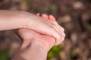 madre e bambino Tenere mani nel il parco. vicino su foto