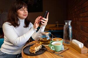 giovane donna con un' smartphone nel un' bar. caffè e tè. foto