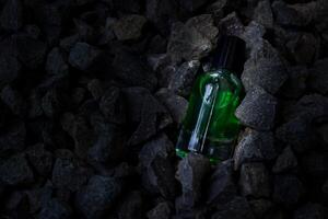 profumo verde trasparente bottiglia nel ghiaia o corallo sfondo foto