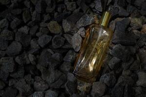 profumo oro trasparente bottiglia nel ghiaia o corallo sfondo foto