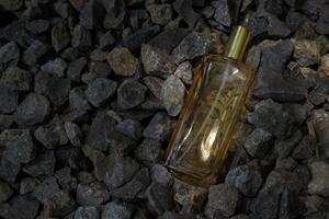 profumo oro trasparente bottiglia nel ghiaia o corallo sfondo foto