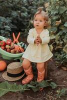carino poco ragazza è raccolta. giardino carriola con verdure e frutta. autunno concetto foto