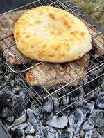 all'aperto barbecue. carne e Pita pane su un' griglia al di sopra di caldo carboni foto