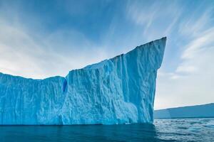 maestoso ghiaccio scogliere incoronato di un' freddo atmosfera, incorniciato di il bellissimo mare e cielo, evocazione un' armonioso panorama di della natura ghiacciato grandezza e oceanico splendore foto