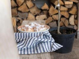 il torte siamo cosparso con in polvere zucchero. il appetitoso torte siamo posto nel un' in profondità ceramica ciotola. foto