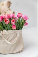 rosa tulipani nel un' tela Borsa Il prossimo per il divano nel un' luminosa interno. copia spazio foto