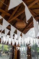 ghirlande di bianca bandiere nel un' di legno gazebo.. estate nozze giardino festa. foto