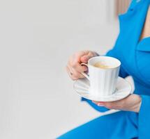 femmina mani Tenere un' tazza di caffè su un' grigio sfondo. copia spazio. bellissimo sfocatura foto