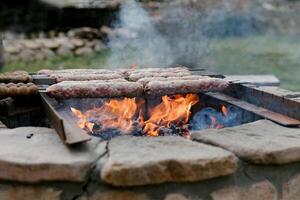 shish kebab su fuoco. parecchi spiedini con carne su il fuoco. bellissimo fuoco. foto