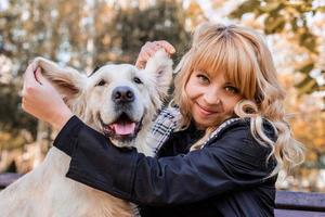 donna caucasica felice che gioca con il suo cane labrador retriever nel parco foto