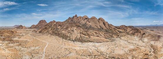 fuco panorama di il Spitzkoppe nel namibia durante il giorno contro un' blu cielo foto