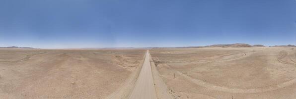 panoramico fuco immagine di un' solitario ghiaia strada attraverso il deserto foto