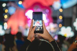 persone Tenere inteligente Telefono e registrazione e Fotografare nel musica Festival concerto foto