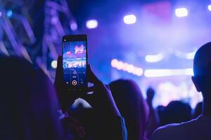 persone Tenere inteligente Telefono e registrazione e Fotografare nel musica Festival concerto foto