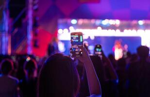 persone Tenere inteligente Telefono e registrazione e Fotografare nel musica Festival concerto foto