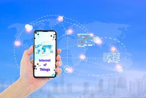 uomo mano Tenere smartphone con Internet di cose parola su schermo e icone collegamento insieme, Internet networking sistema concetto foto