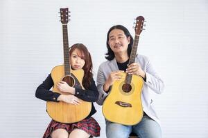 ritratto di asiatico famiglia duo gruppo musicale con Due chitarrista di padre e figlia su bianca sfondo per musica, artista, musicista stile concetto foto