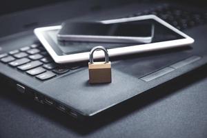 lucchetto con laptop, smartphone e tablet. Internet e sicurezza tecnologica foto