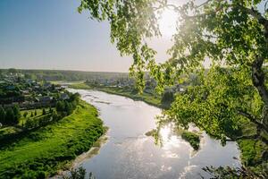 soleggiato villaggio fiume e sospeso ponte foto