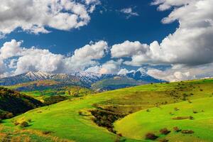 colline e montagne coperto con giovane verde erba e illuminato di il sole su un' soleggiato giorno. foto