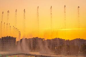grande fontane su il artificiale stagno, illuminato di luce del sole a tramonto nel compito città parco a estate. foto