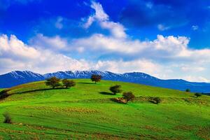 colline e montagne coperto con giovane verde erba e illuminato di il sole su un' soleggiato giorno. foto