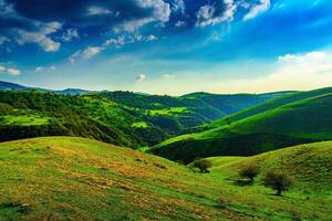 colline e montagne coperto con giovane verde erba e illuminato di il sole su un' soleggiato giorno. foto