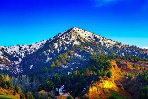 montagna superiore coperto con giovane neve e illuminato di il sole su un' soleggiato giorno. montagna paesaggio. foto