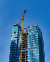 un' gru edificio un' grattacielo contro un' blu cielo. foto