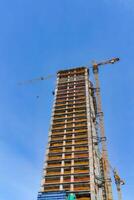 un' gru edificio un' grattacielo contro un' blu cielo. foto