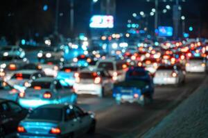sfocato auto traffico leggero a notte città. traffico marmellata nel sera corsa ora. foto
