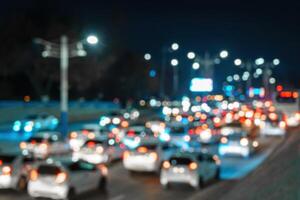 sfocato auto traffico leggero a notte città. traffico marmellata nel sera corsa ora. foto
