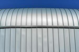 un' moderno edificio coperto con metallo alluminio pannelli contro il blu cielo. foto