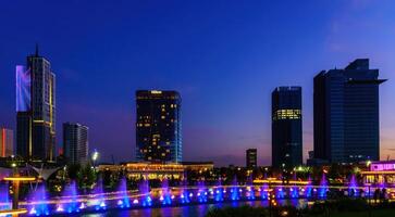 Uzbekistan, compito - settembre 29, 2023 un' Fontana con laser illuminazione e leggero musica nel compito città parco a ore notturne e grattacieli. foto