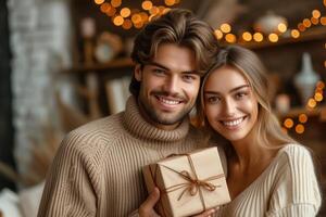 sorridente coppia con un' regalo scatola, accogliente festivo luci nel il sfondo. foto