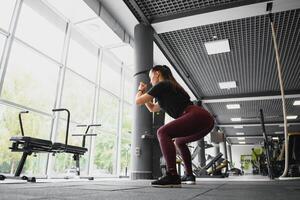 lato Visualizza ritratto di un' giovane donna fare squat a fitness palestra. foto