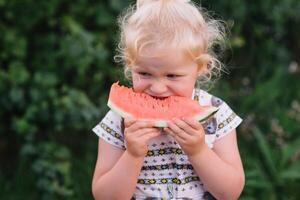 bellezza poco ragazza mangiare anguria nel parco. foto