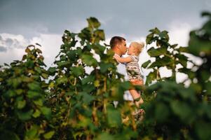 ritratto di carino poco ragazza tenuto nel Il padre di braccia. contento amorevole famiglia. padre e il suo figlia bambino ragazza giocando abbracciare. carino bambino e papà. foto