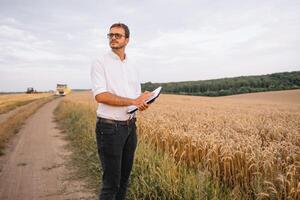 giovane contadino ingegnere in piedi su Grano campo foto