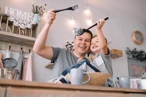 giovane uomo e il suo figlio con forno foglio nel cucina. padre con poco figlio su il cucina. foto