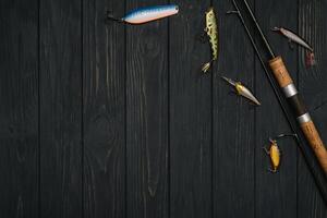 pesca affrontare - pesca Filatura, ganci e esche su scurire di legno sfondo. superiore Visualizza foto