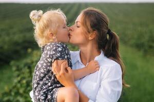 elegante madre e figlia avendo divertimento su il natura. contento famiglia concetto. bellezza natura scena con famiglia all'aperto stile di vita. contento famiglia riposo insieme. felicità nel famiglia vita. madri giorno foto