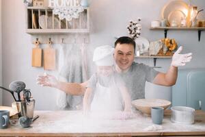 giovane uomo e il suo figlio con forno foglio nel cucina. padre con poco figlio su il cucina. foto